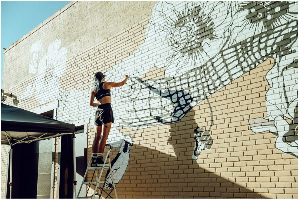 Successful art business owner and muralist Alli K painting