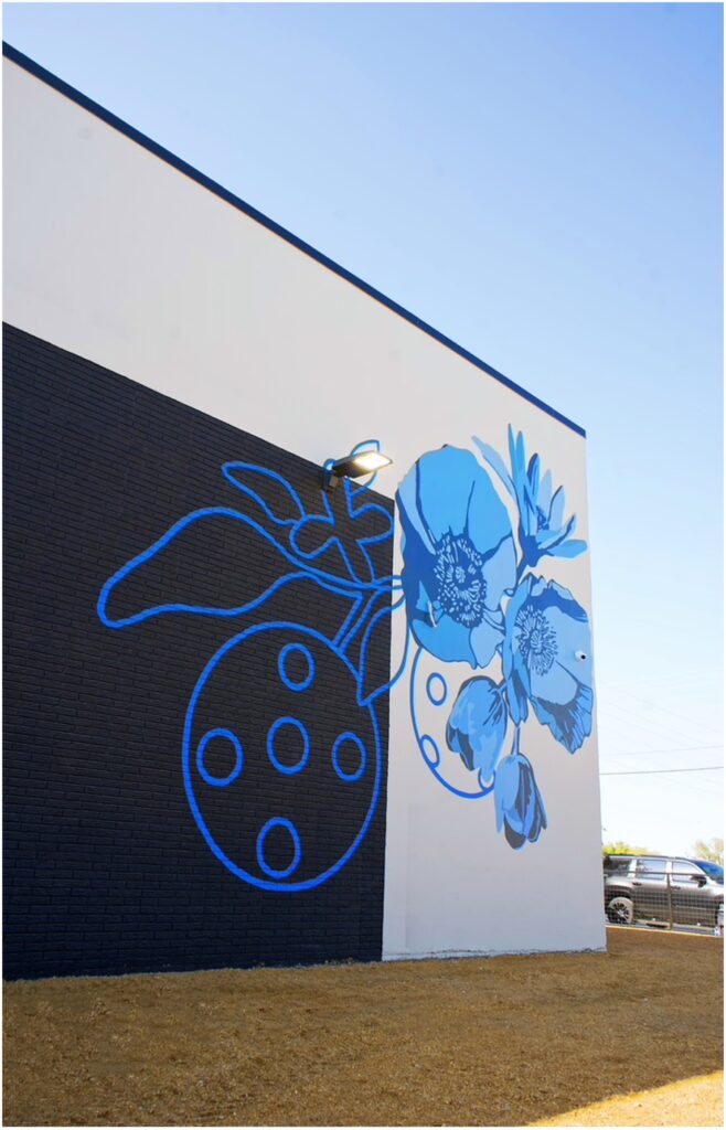 A blue floral mural on the outside of At Fault Pickleball in Dallas, painted by Alli K Design
