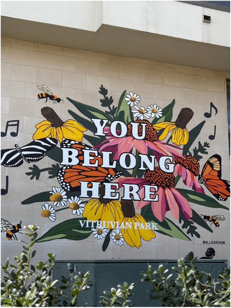A colorful floral mural that says You Belong Here by Texas muralist Alli K Design