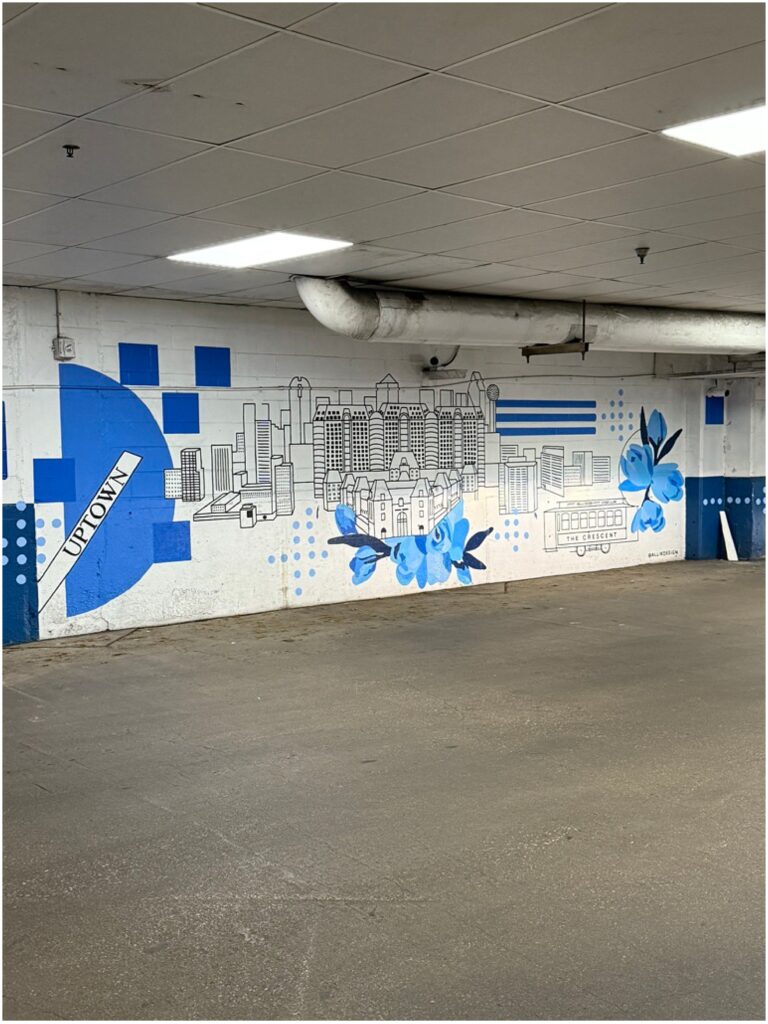Graphic black and white mural with blue accents in a Dallas parking garage at The Crescent